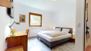 - une chambre avec un lit, un bureau et une fenêtre dans l'établissement Ferienwohnung Kathrin, à Huben