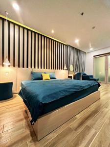 a bedroom with a large bed with a blue blanket at Oceanami 5 Bedrooms Private Pool in Long Hai