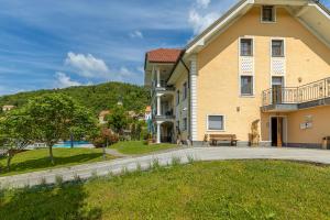 a large yellow building with a bench in front of it at Pool Villa Silva Marija Apartments in Pišece