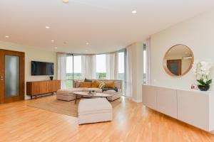 een woonkamer met een bank en een spiegel bij Meilės Uostas in Šventoji