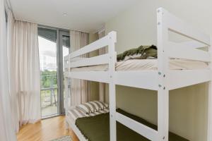 een wit stapelbed in een kamer met een raam bij Meilės Uostas in Šventoji