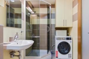 een badkamer met een wasmachine en een wastafel bij Meilės Uostas in Šventoji +26 foto's