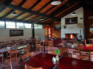 a restaurant with tables and chairs and a fireplace at Harrietville Hotel Motel in Harrietville