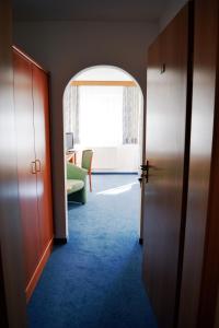 an entrance to a room with a door and a room with a chair at A8 Hotel im Darchinger Hof, Bed & Breakfast in Weyarn