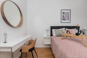 1 dormitorio con cama, escritorio y espejo en Apartament VESPA Beach Nearby by Renters, en Gdynia