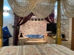 ein Schlafzimmer mit einem Bett und einer Badewanne in einem Zimmer in der Unterkunft צימר מאיה in Ani'am