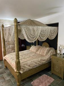 a bedroom with a canopy bed and a table at צימר מאיה in Ani'am