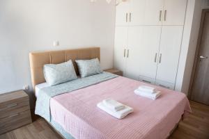 1 dormitorio con 1 cama con 2 toallas en Renovated apartment 5min from subway station 'Attiki' en Atenas