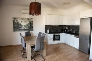 a kitchen with a table and chairs and a refrigerator at Renovated apartment 5min from subway station 'Attiki' in Athens