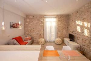 a living room with a brick wall at Apartamento histórico en el Barri Vell Girona in Girona