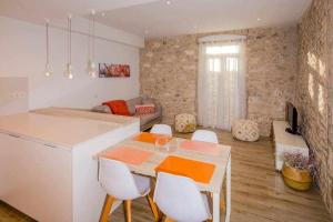 ジローナにあるApartamento histórico en el Barri Vell Gironaのキッチン、リビングルーム(テーブル、椅子付)