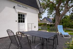 um pátio com uma mesa e cadeiras em frente a uma casa em Ferienhaus Pernice em Freest