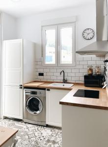 a white kitchen with a washer and dryer in it at Estudio 33 in San Juan de la Arena
