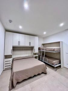 een slaapkamer met een bed en 2 stapelbedden bij Residence TERRAMARE in Lido di Jesolo