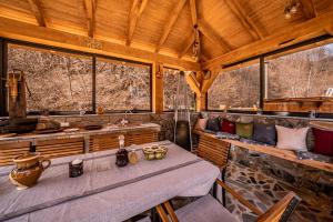 a room with a table and chairs and windows at CABANELE IULI'S HOME in Runcu