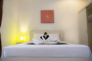 una camera da letto con un letto con lenzuola bianche di Gaing Mas Residence By Gaing Mas Group a Jimbaran