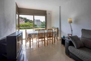 sala de estar con mesa, sillas y sofá en Apartamento con parking privado en Girona, en Girona