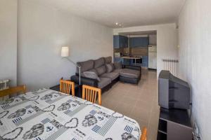 ジローナにあるApartamento con parking privado en Gironaのベッド1台、ソファ、リビングルームが備わります。