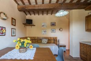 a room with a bed and a table with flowers on it at Poggio Primo - Bilocale Cavaliere in Castiglion Fibocchi