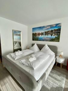 ein Schlafzimmer mit einem großen Bett mit weißer Bettwäsche in der Unterkunft Seeblickapp. „Eure Auszeit“ in Goslar