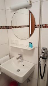 a bathroom with a sink and a mirror at Landgasthof Groh in Ulrichstein