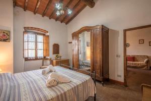 ein Schlafzimmer mit einem großen Bett und einem Spiegel in der Unterkunft Poggio Primo - Bilocale Prunalbo in Castiglion Fibocchi