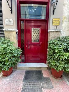 uma porta vermelha num edifício com duas plantas em cozy minimal apartment em Piraeus