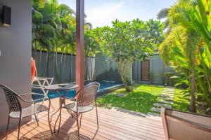 a patio with chairs and a table on a deck at Two Bedroom Onyx Villa Nai Harn in Nai Harn Beach