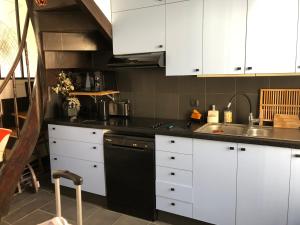 cocina con armarios blancos y lavavajillas negro en La belle des écores maison centre Trouville, en Trouville-sur-Mer
