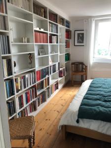 1 dormitorio con una gran estantería llena de libros en La belle des écores maison centre Trouville, en Trouville-sur-Mer
