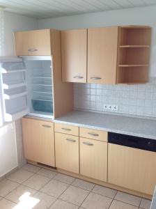 a kitchen with wooden cabinets and an empty refrigerator at Ruhige Wohnung in Schnaitheim bei Heidenheim in Heidenheim an der Brenz