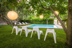 a group of white chairs and a swimming pool at Quiet Villa near Split, Heated Pool, View, Nature in Klis