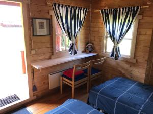 Pärna的住宿－Merejussi Puhkemajad，小屋内带床和椅子的房间