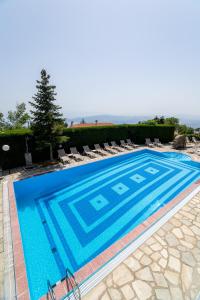 a large swimming pool with chairs and a tree at Portaria Hotel in Portariá