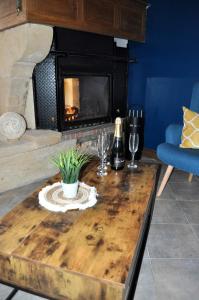 a living room with a table with a fireplace at Les Antonins in Marville