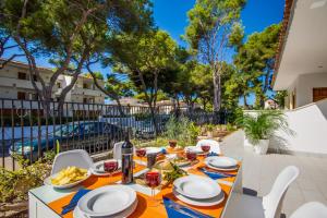 a table with food and wine on a patio at Ideal Property Mallorca - Villa Rosita 12 in Alcudia