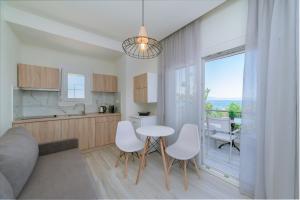 a kitchen with a table and chairs and a window at Summer Feelings in Skala Sotiros