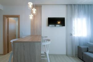 a kitchen with a bar with a tv on the wall at Summer Feelings in Skala Sotiros