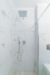 a bathroom with a shower with white marble walls at Summer Feelings in Skala Sotiros