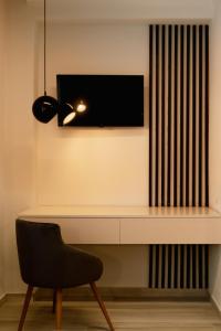 a desk with a chair and a television on a wall at Summer Feelings in Skala Sotiros