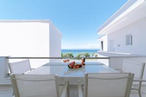 a table with chairs and a bowl of fruit on a balcony at Summer Feelings in Skala Sotiros