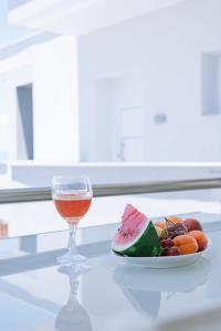 a plate of fruit and a glass of wine on a table at Summer Feelings in Skala Sotiros