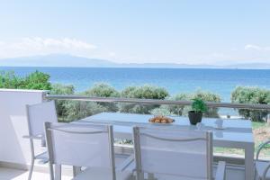 a table and chairs on a balcony with a view of the ocean at Summer Feelings in Skala Sotiros