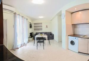 a kitchen and living room with a table and a couch at Frygano Apartments 2 in Oitylo