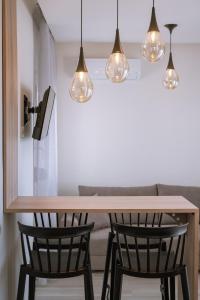 a kitchen with a table with two chairs and lights at Summer Feelings in Skala Sotiros