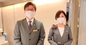 un hombre y una mujer usando máscaras en una habitación en Nagoya Fushimi Mont-Blanc Hotel, en Nagoya