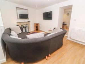 sala de estar con sofá y TV en Rose Bank Cottage en Penzance