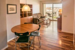 ジローナにあるApartamento con terraza y parking privado Gironaのリビングルーム(木製テーブル、椅子付)