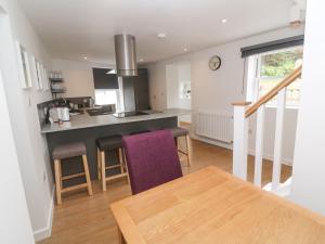 a kitchen and living room with a table and chairs at Rose Bank Cottage in Penzance