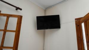 a flat screen tv hanging on a wall at SOULA ROOMS in Kini